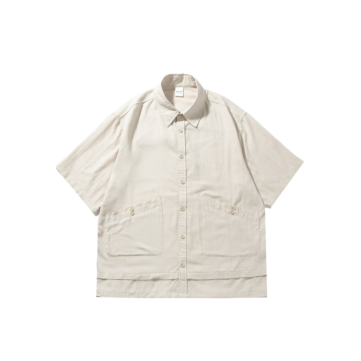 Beige short-sleeve button-up shirt flat lay with pointed collar, two large patch pockets and layered hem