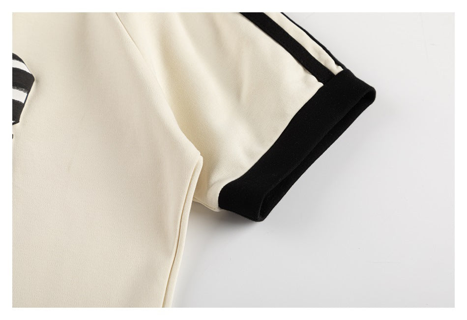 Close-up of a cream sleeve with a wide black cuff and black shoulder trim.