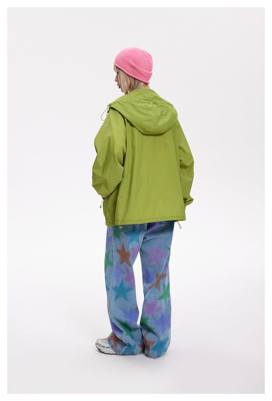 Model viewed from behind wearing a lime-green hooded jacket with elastic cuffs and hem drawcords.