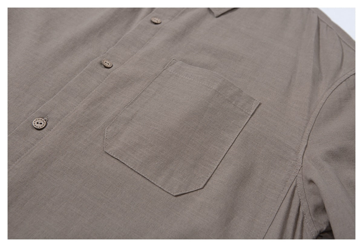 Close-up of the taupe shirt's front chest pocket, stitching, and matching buttons.