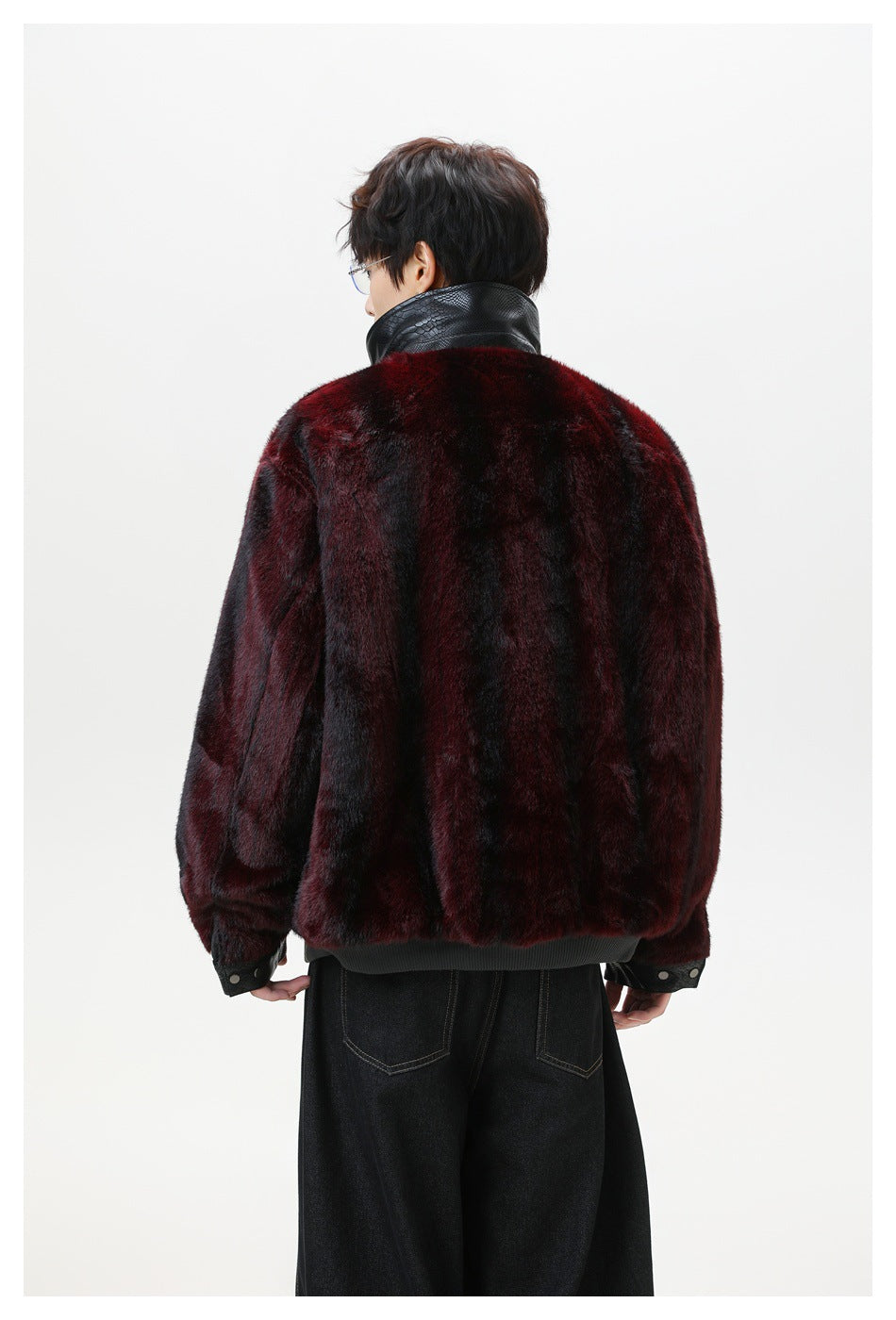 Back view of a model wearing a burgundy-and-black plush jacket with a black textured collar and cuffs.