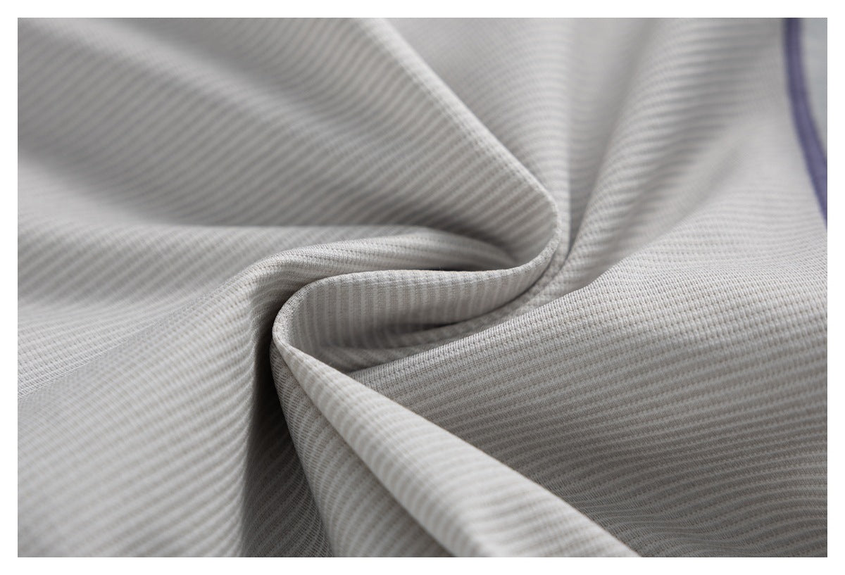 Close-up of light gray ribbed fabric gathered into folds, with a narrow purple edge at right.