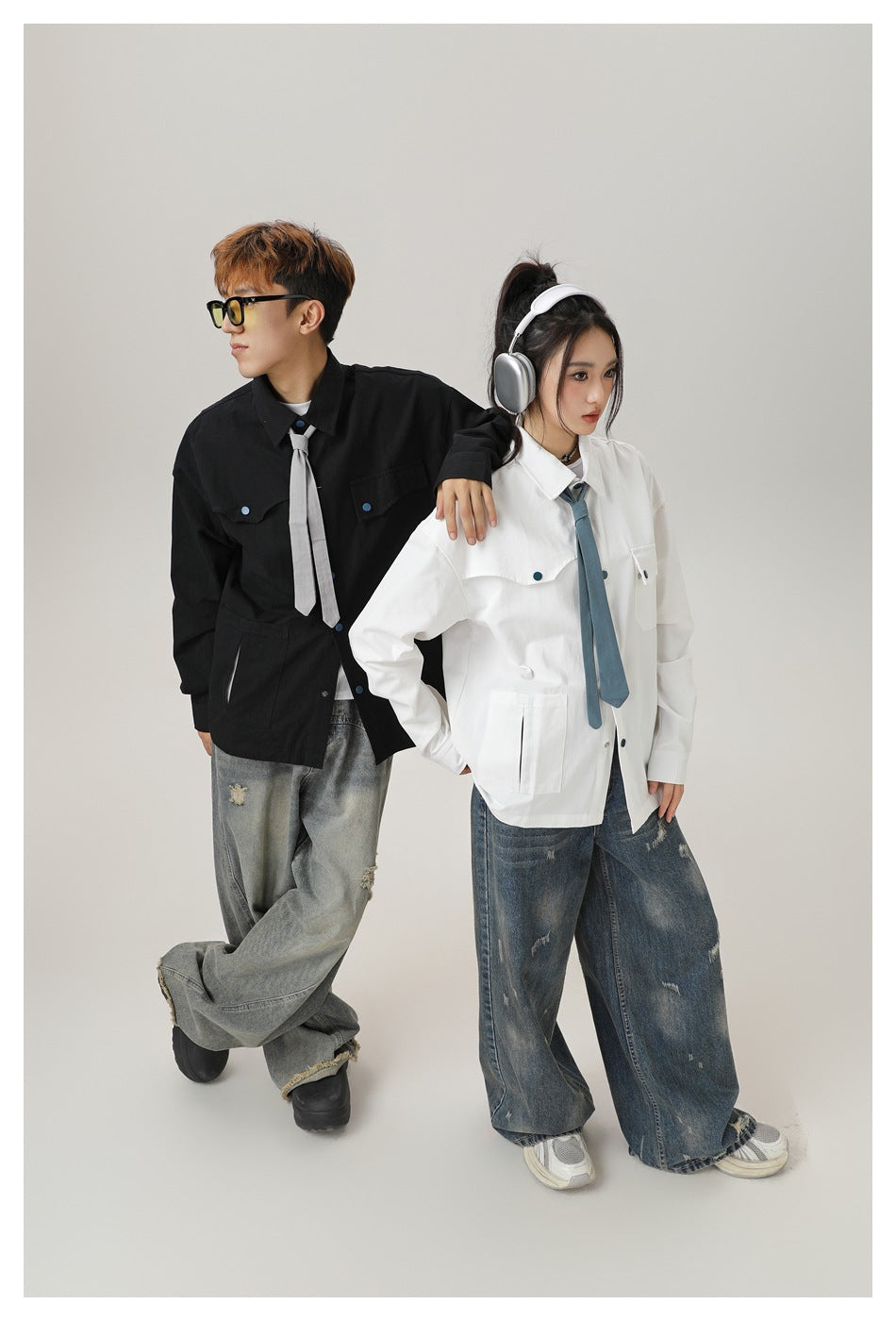 Two models posing in black and white pocket shirt jackets with ties, styled with baggy distressed jeans