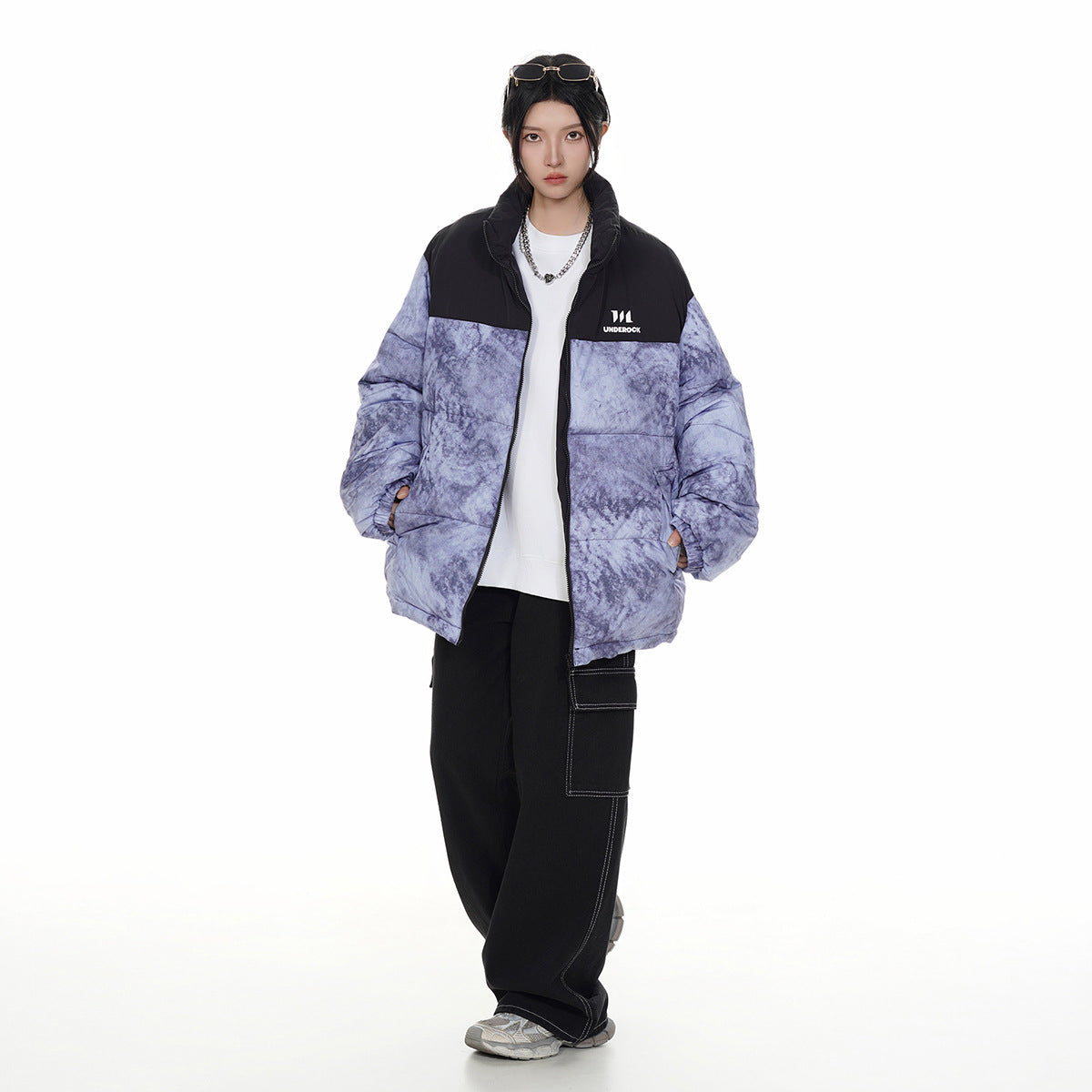 Model wearing a lavender-gray marbled puffer jacket with black yoke and collar, styled with black pants.