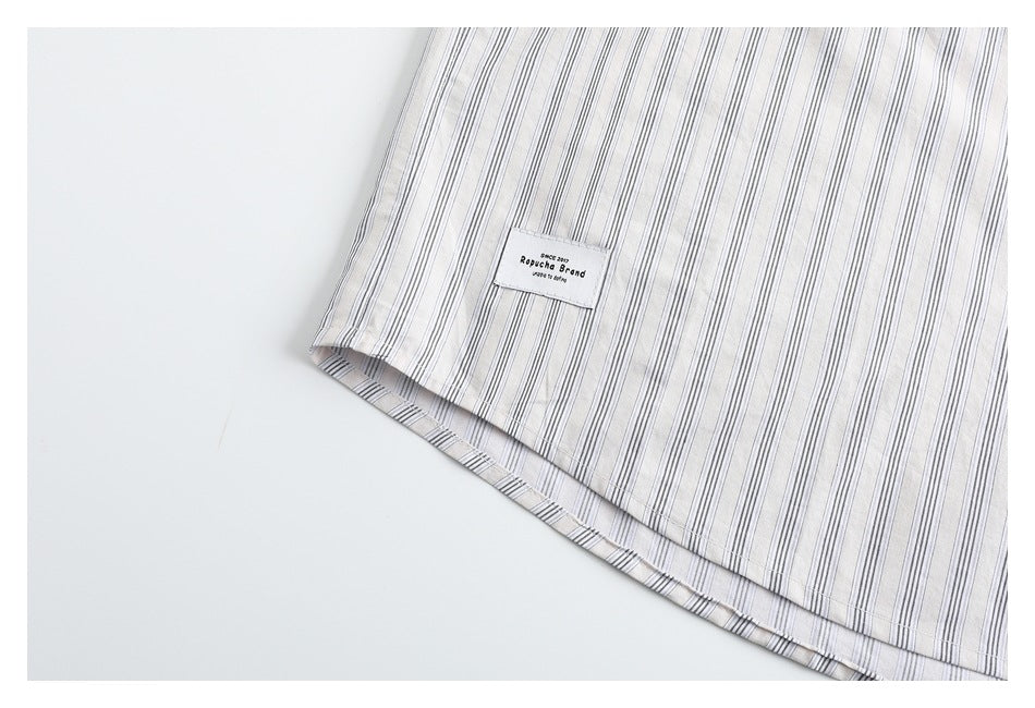 Close-up of the striped shirt hem with a small sewn brand label.