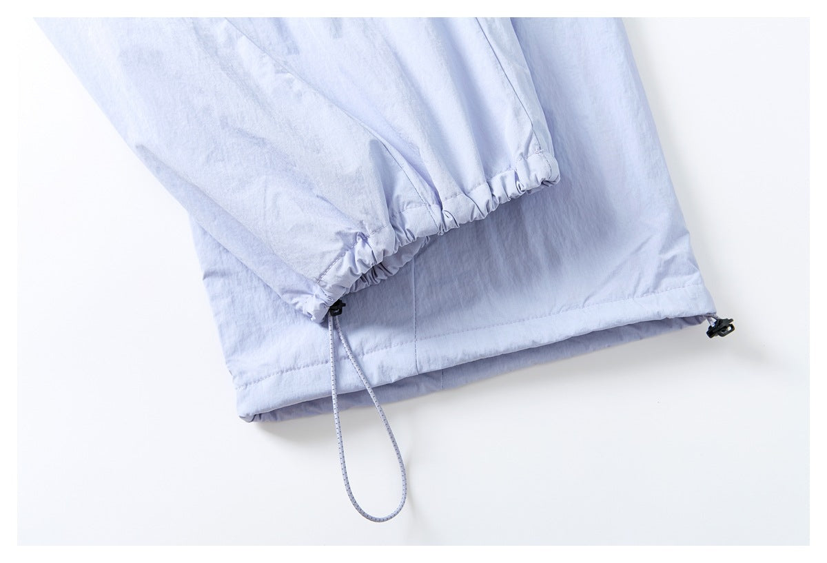Close-up of pale lavender pants showing an elasticated hem with an adjustable drawcord and toggle.