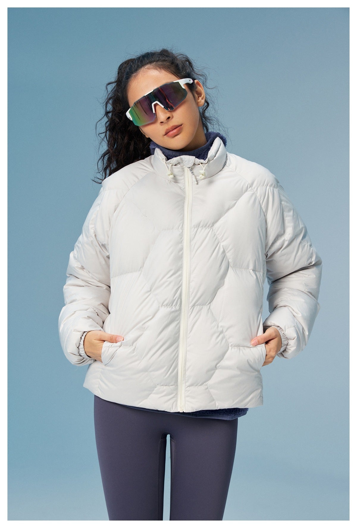 Model wearing a white quilted zip-up jacket with a high collar and side pockets, shown from the front.