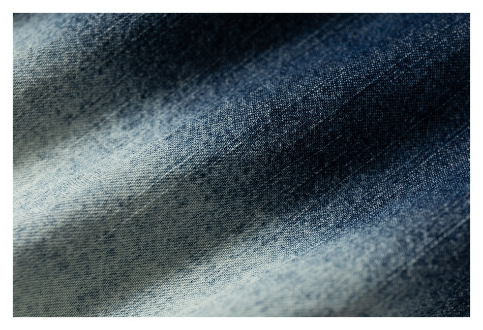 Extreme close-up of textured blue denim with light and dark faded areas.