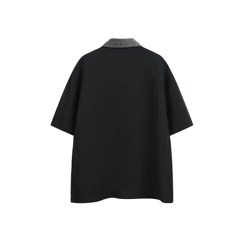 Back view of a black short-sleeve shirt with a contrasting gray textured collar.