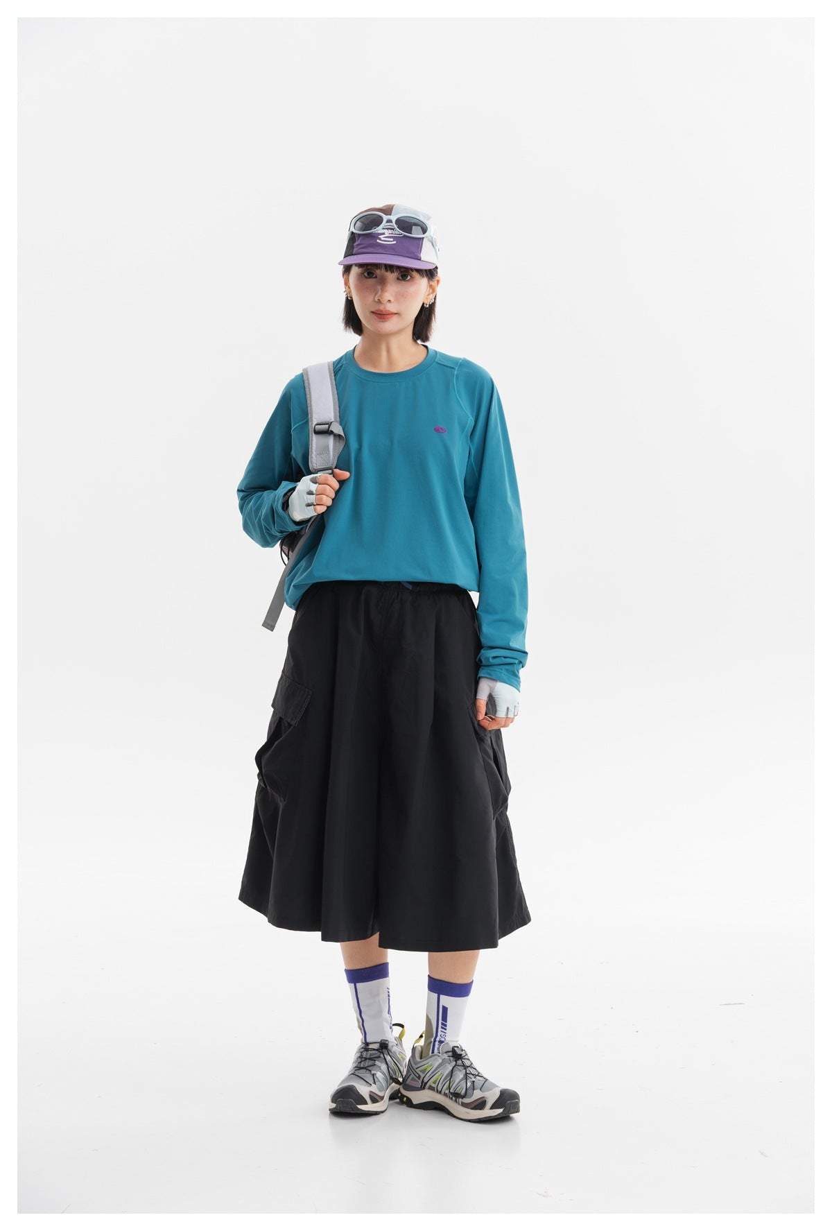 Model wearing a teal long-sleeve top and black cargo midi skirt, front view.