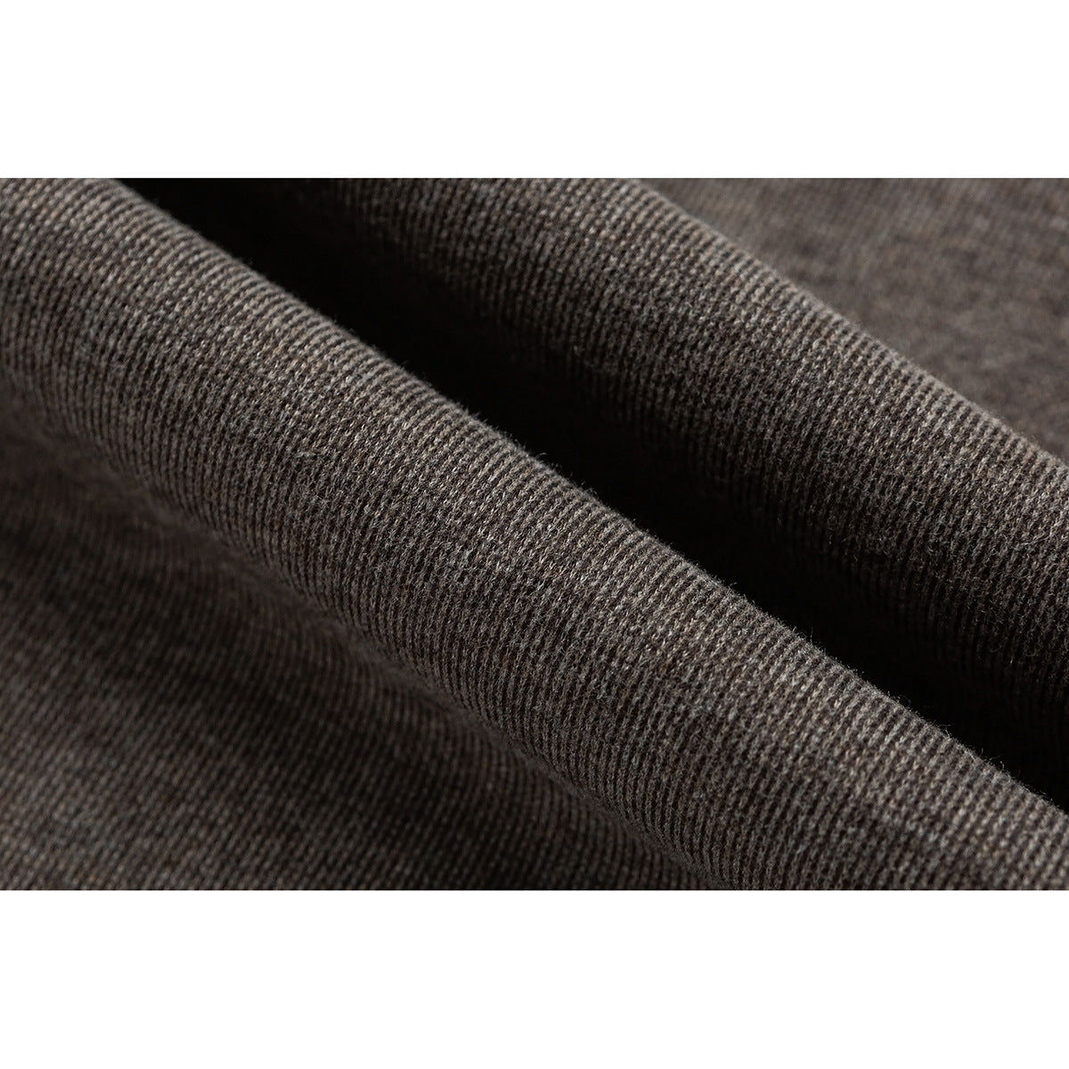 Macro view of dark taupe heathered knit fabric folded to show its ribbed texture.