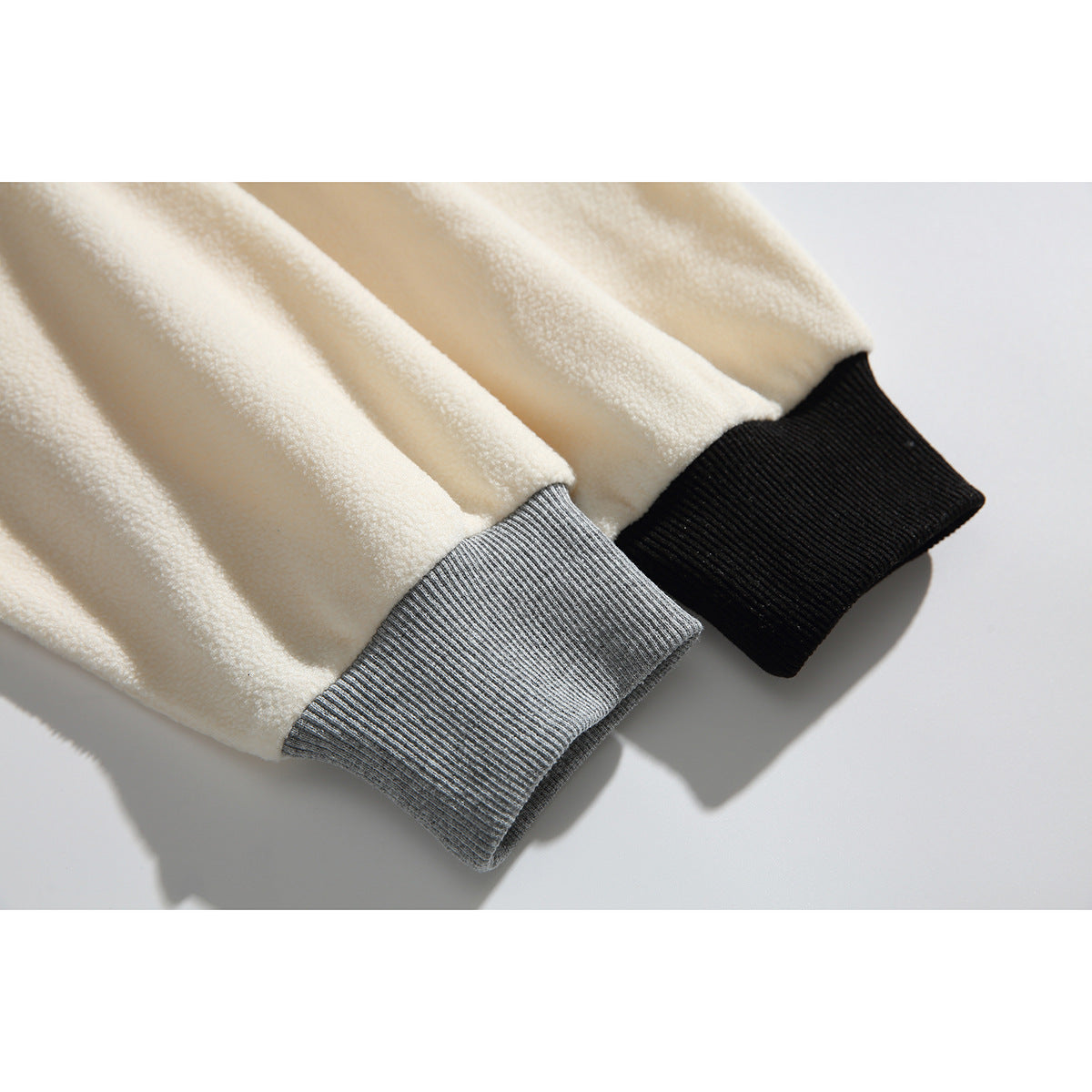 Close-up of ivory sleeves with contrasting gray and black ribbed cuffs.