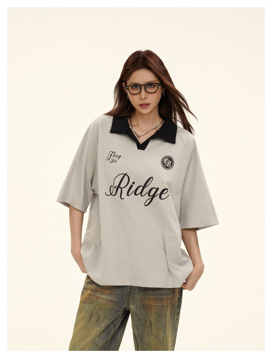 Close-up of model wearing gray polo-style T-shirt with black collar and script Ridge graphic