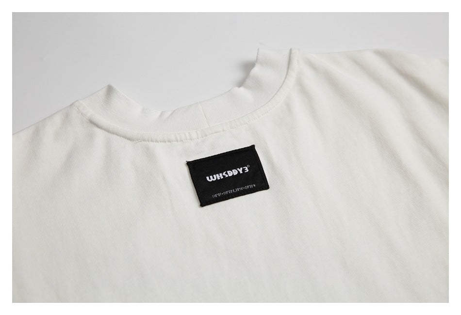 Close-up of an off-white T-shirt with a black sewn label at the back neckline.