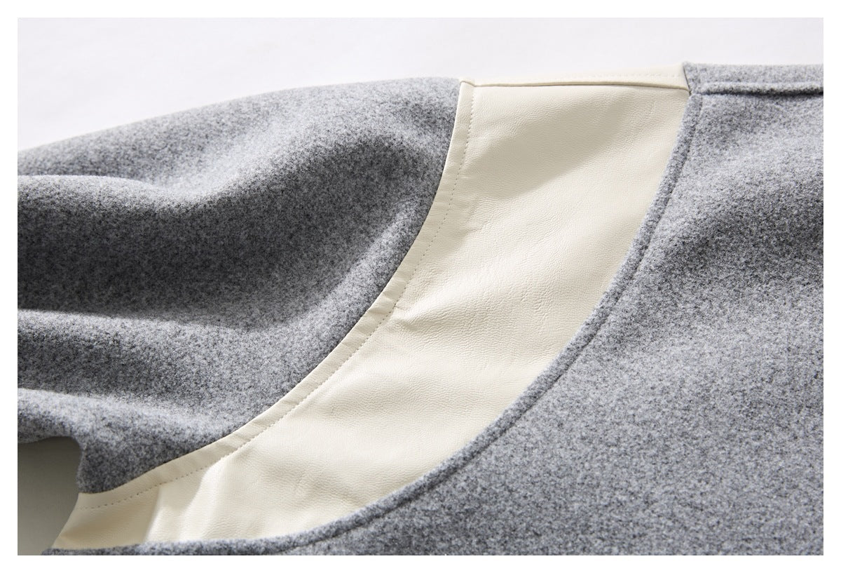 Close-up of cream-colored lining or trim set against the heather gray garment.