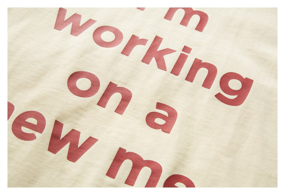 Close-up of cream fabric with large red English lettering printed diagonally across it.