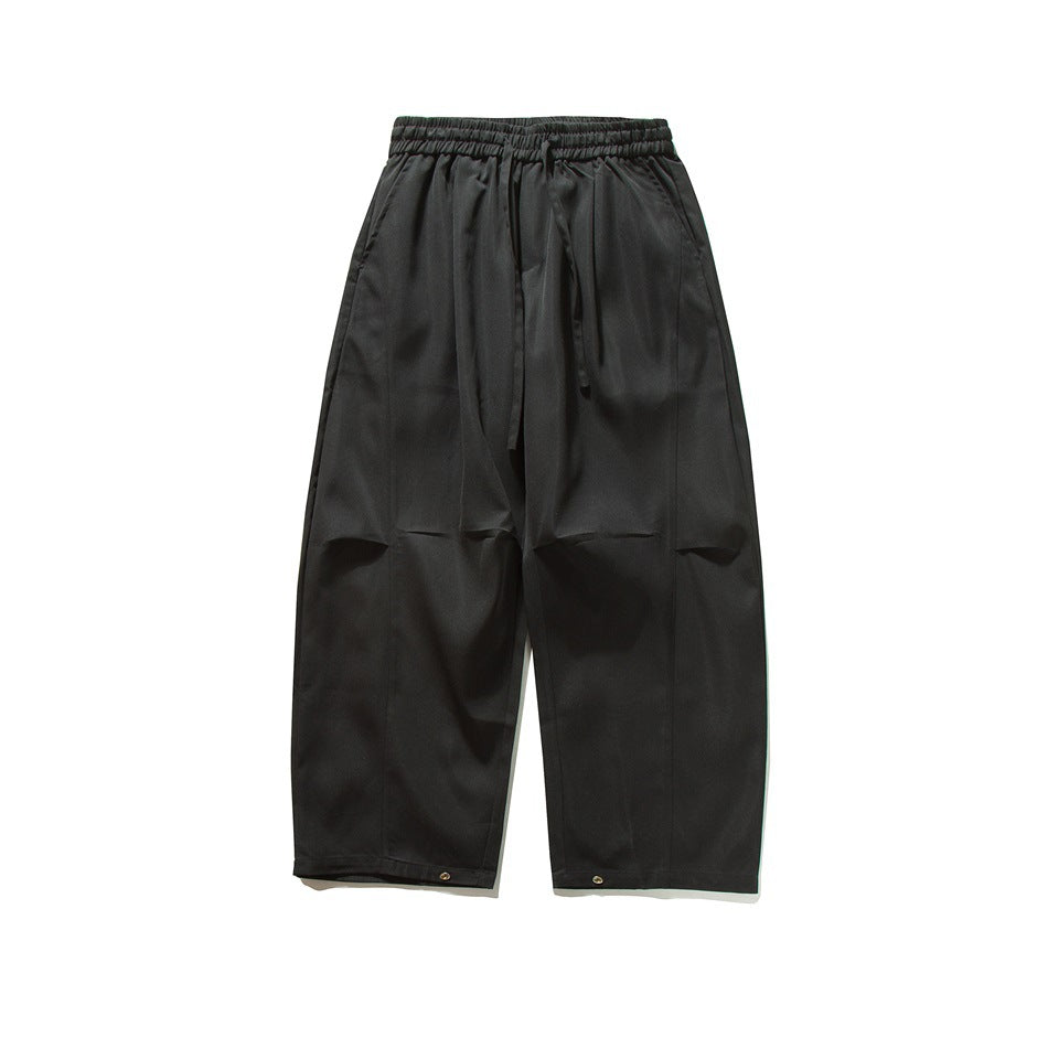 Black wide-leg drawstring pants, flat front view with knee folds and hem snaps