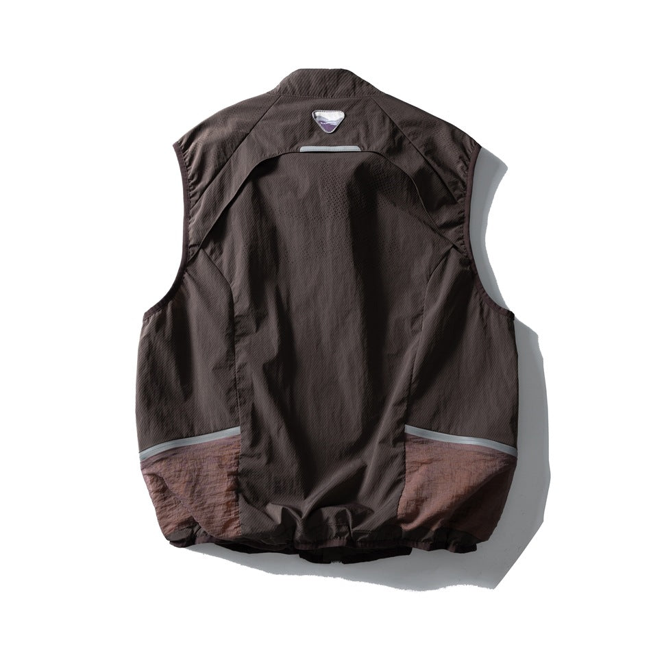 Back of a dark brown sleeveless vest with curved panels, reflective trim, and muted mauve lower sections.