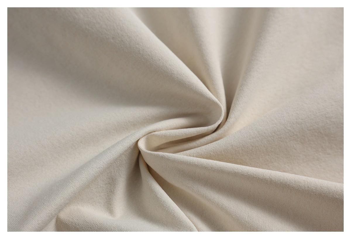 Close-up of smooth light beige fabric draped into soft folds.