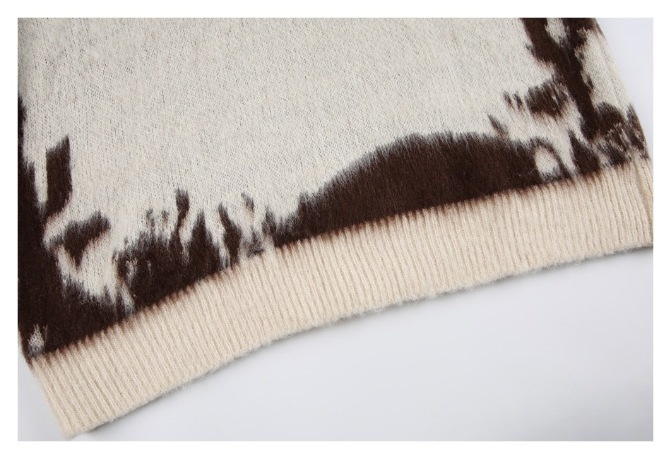 Close-up of a cream ribbed sweater hem with dark brown patterning above it.