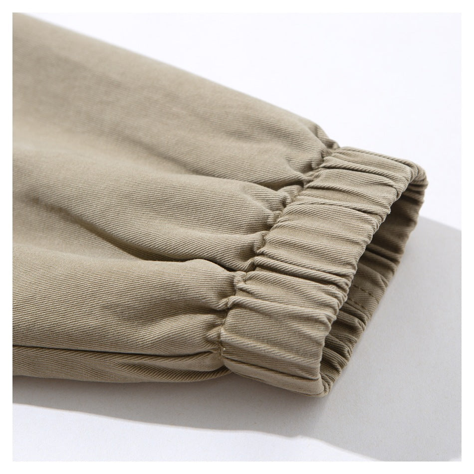 Close-up of a gathered elastic cuff on a beige garment, with visible stitching.