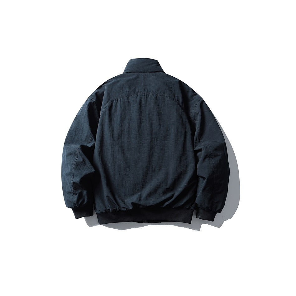 Navy bomber-style jacket back view showing stand collar, back yoke seam and black ribbed cuffs and hem