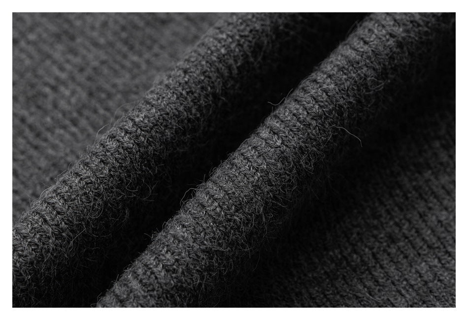 Extreme close-up of the fuzzy gray knit texture and folded garment edge.