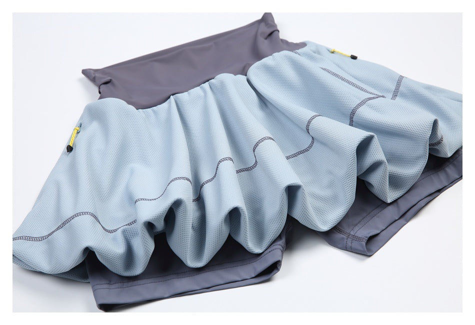 Light blue textured athletic skirt with a slate-gray waistband, curved stitched seams, and yellow side zipper pulls, laid