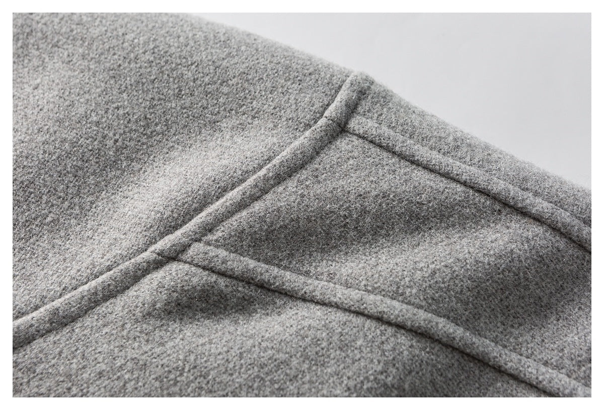 Close-up of gray mottled garment fabric with intersecting raised seams.