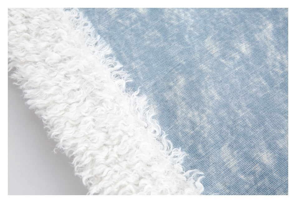 Close-up showing the boundary between white curly trim and light blue denim.