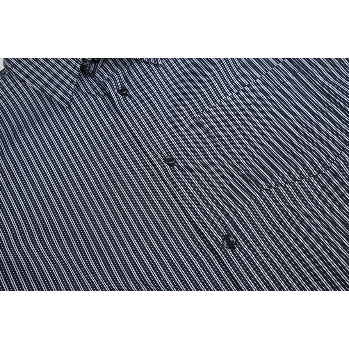 Close-up of a dark shirt with thin white stripes, showing its button placket and chest pocket.