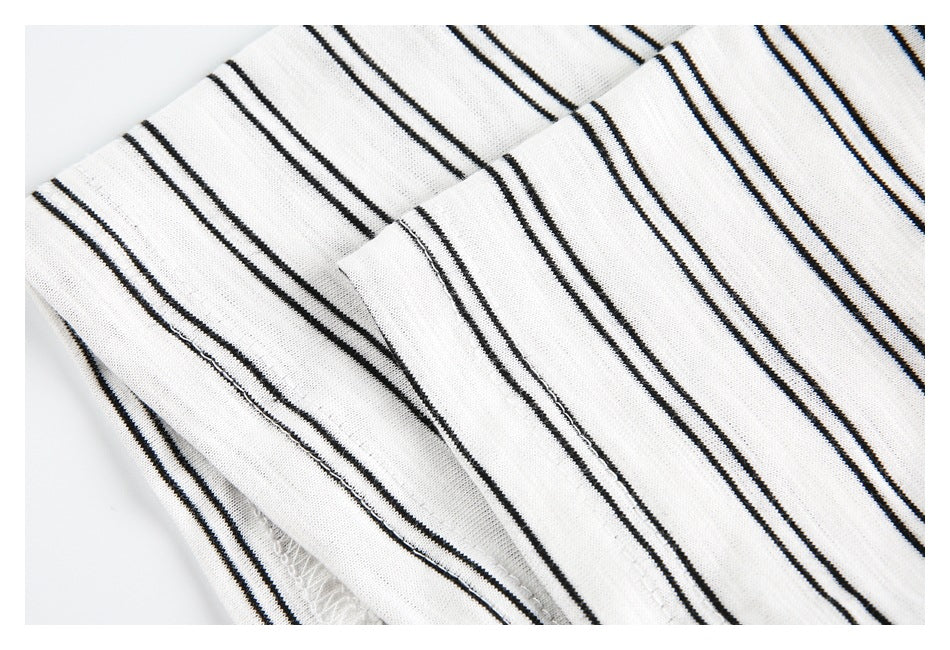 Close-up of a folded section of the white striped top showing its seam and stitching.