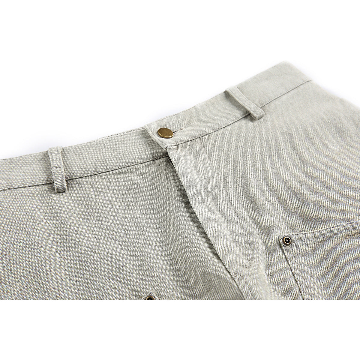 Close-up of light gray shorts showing the waistband, belt loops, brass button, fly, and pocket edge.