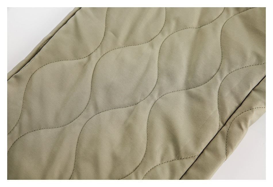 Close-up of olive-khaki fabric with curved quilted stitching.