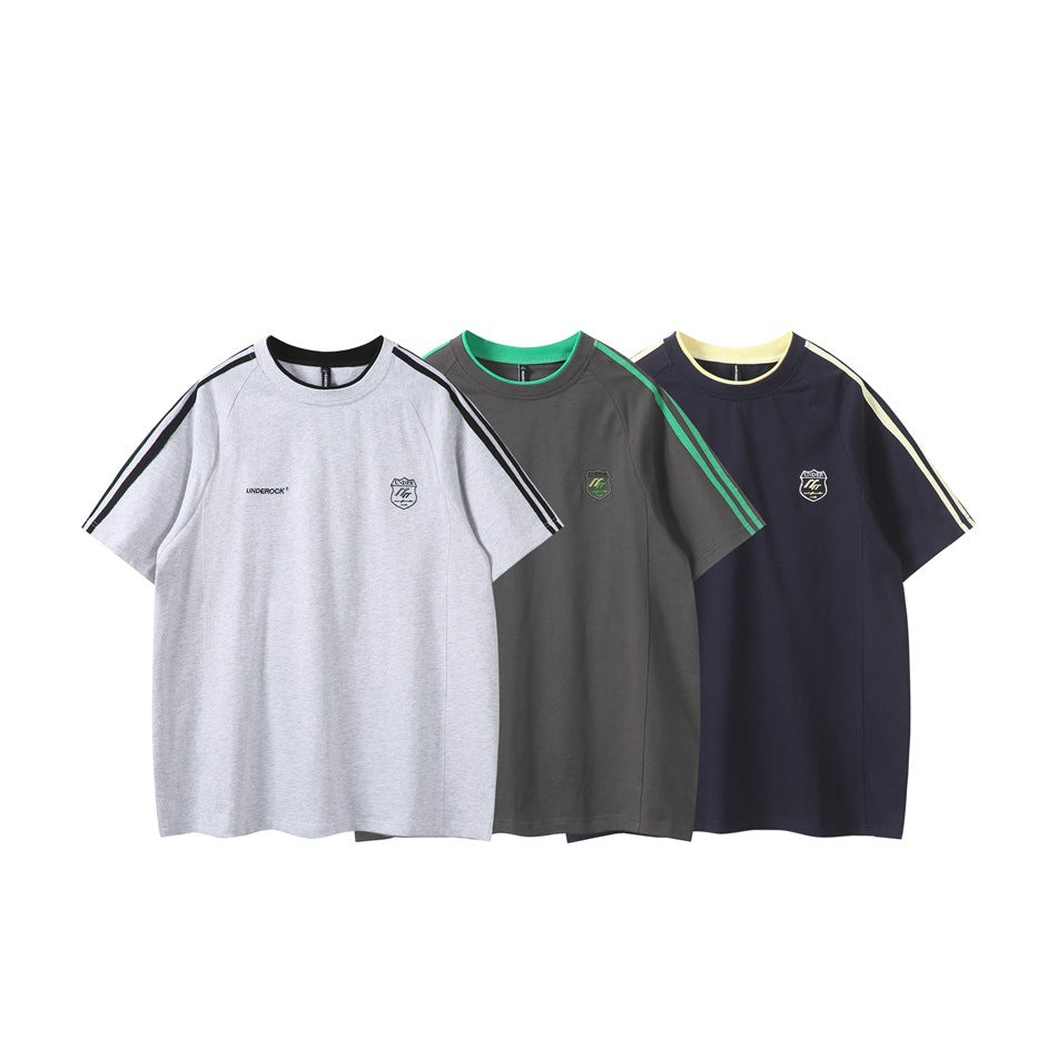 Front views of short-sleeve T-shirts in light gray, charcoal, and navy, with contrasting shoulder stripes and chest logos.