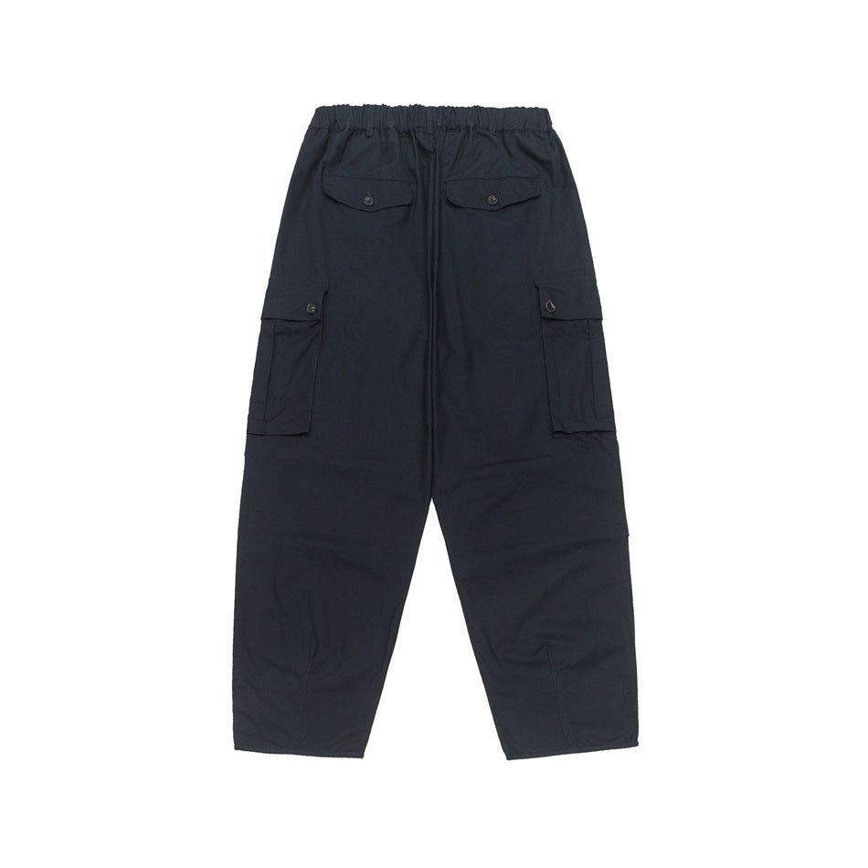 Rear view of navy cargo pants with an elastic waist and button-flap back and side pockets.