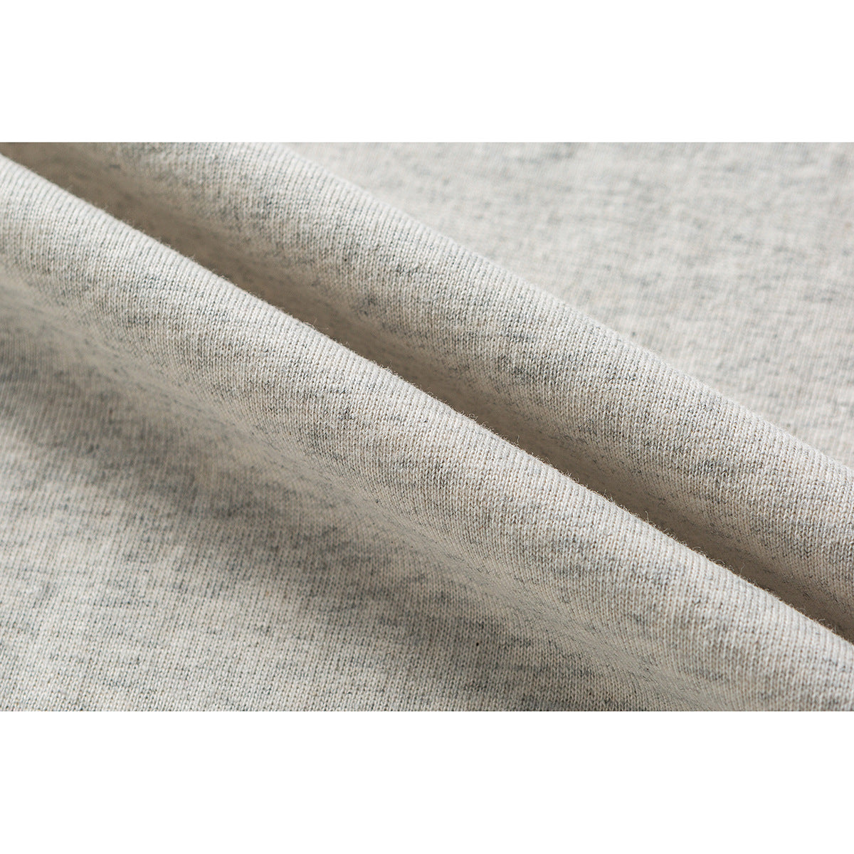 Close-up of light heather gray knit fabric arranged in soft diagonal folds.