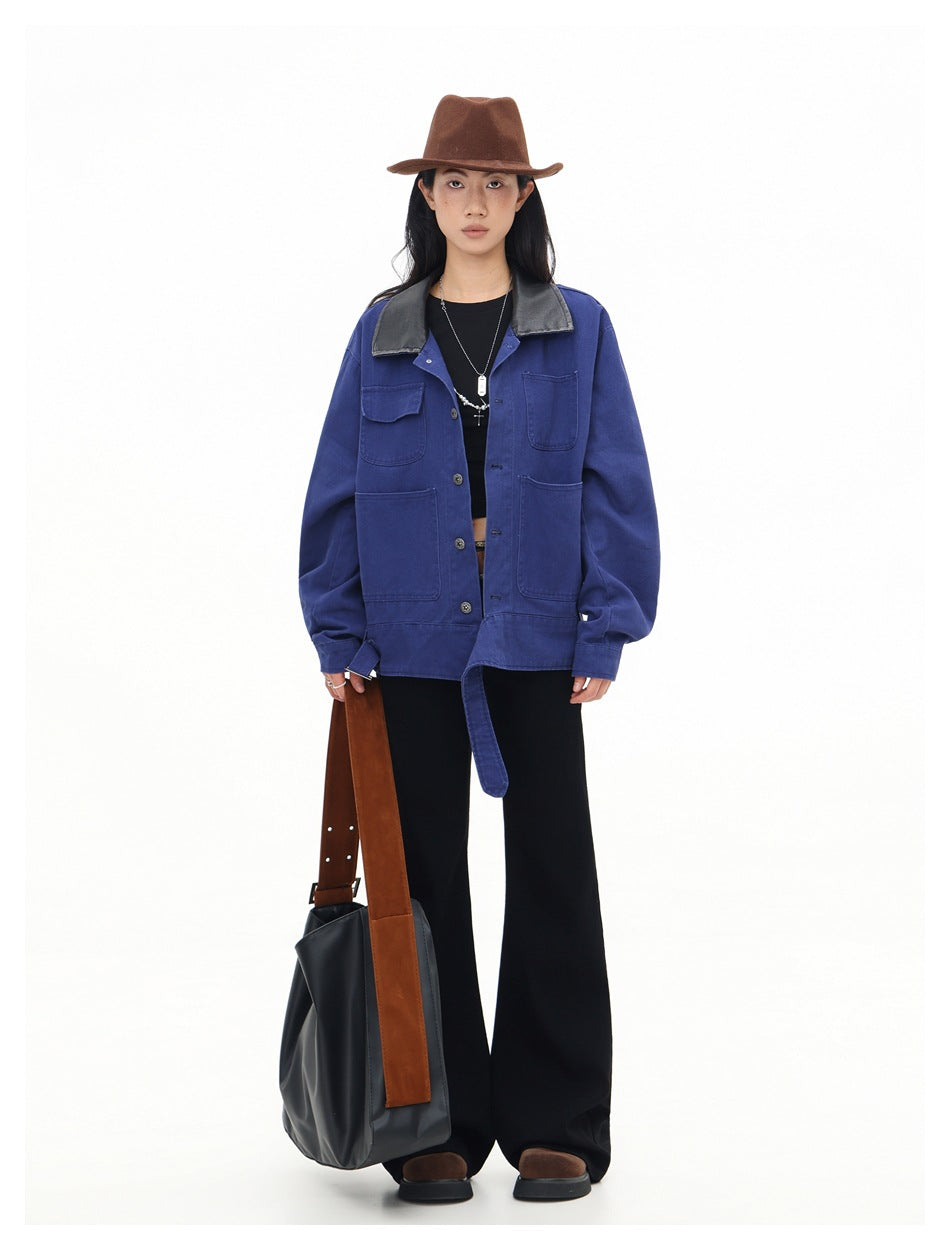 Model wearing a blue utility jacket with a black collar and four front pockets, shown with black trousers.