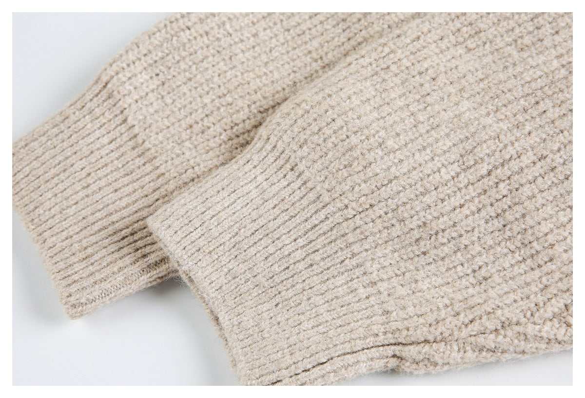Close-up of a beige knit garment's ribbed cuff or hem beside textured fabric.