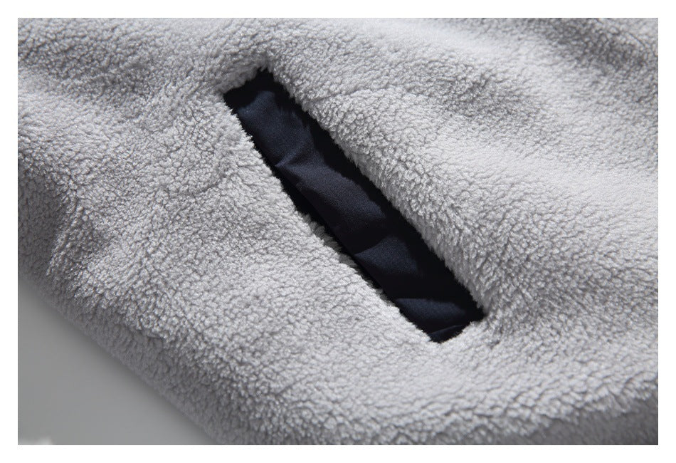 Close-up of a dark-lined pocket opening in the light gray fleece garment.