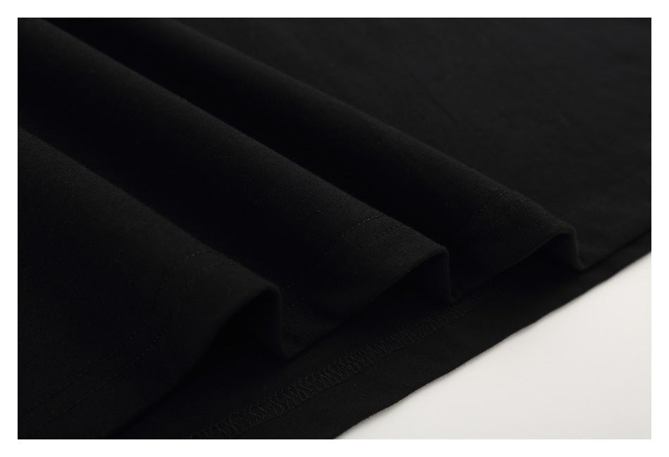 Close-up of the folded, stitched hem of a black T-shirt.