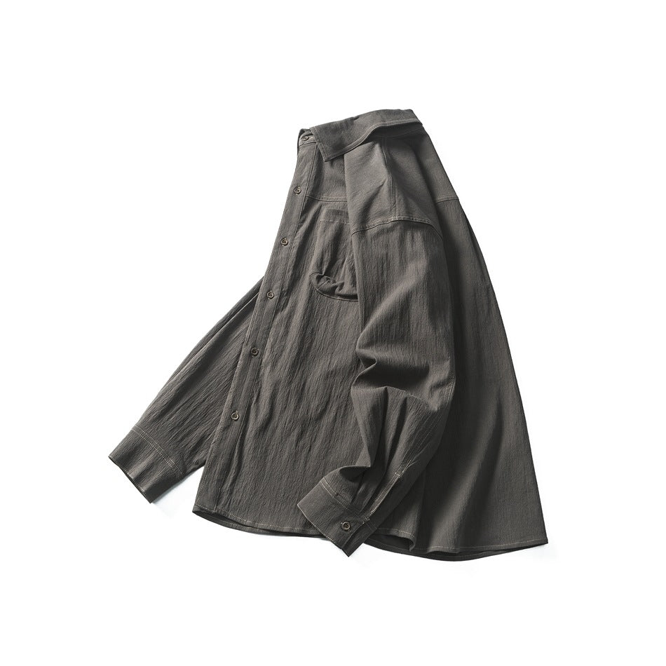Angled front view of a charcoal button-up shirt with a pointed collar, chest pocket, contrast stitching, and button cuffs.