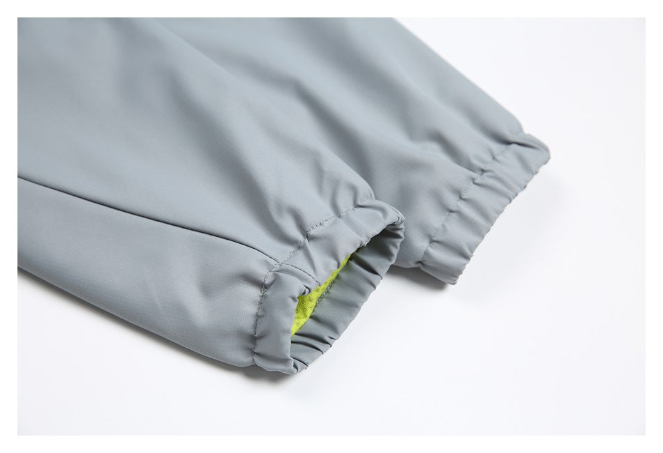 Close-up of a light gray garment sleeve cuff with gathered elastic and a glimpse of bright yellow lining.