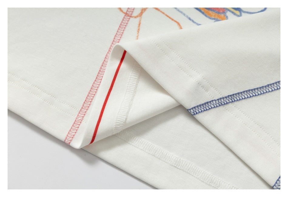 Close-up of the white shirt's inside seams and hem, showing red and blue overlock stitching.