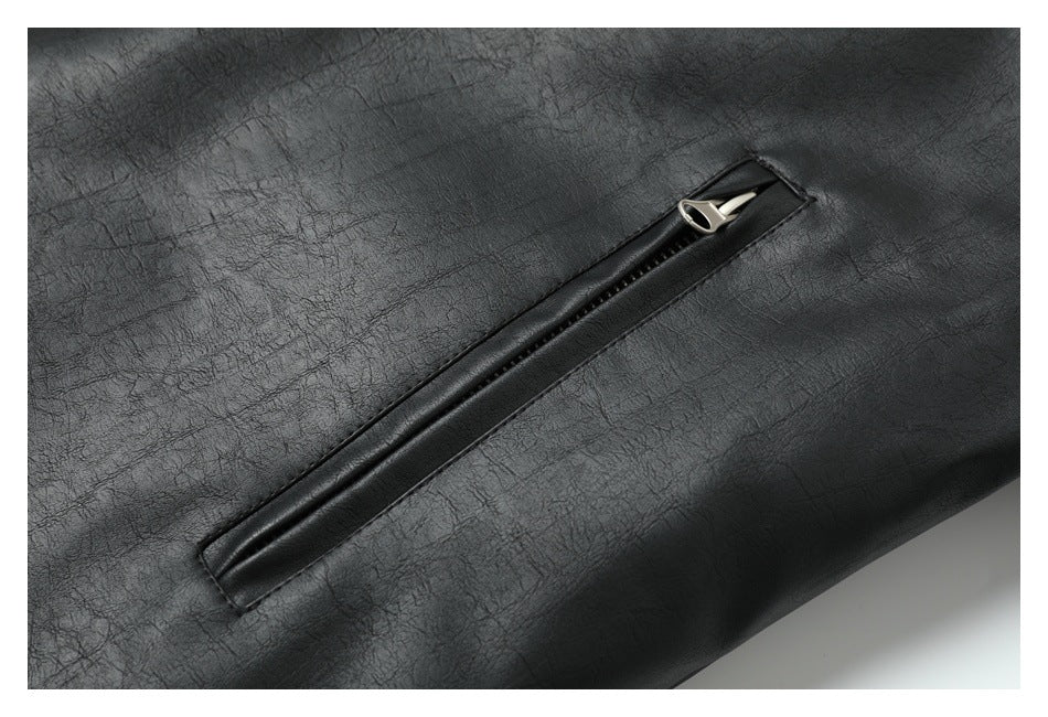 Close-up of a black jacket’s textured surface and diagonal zip pocket with a silver pull.