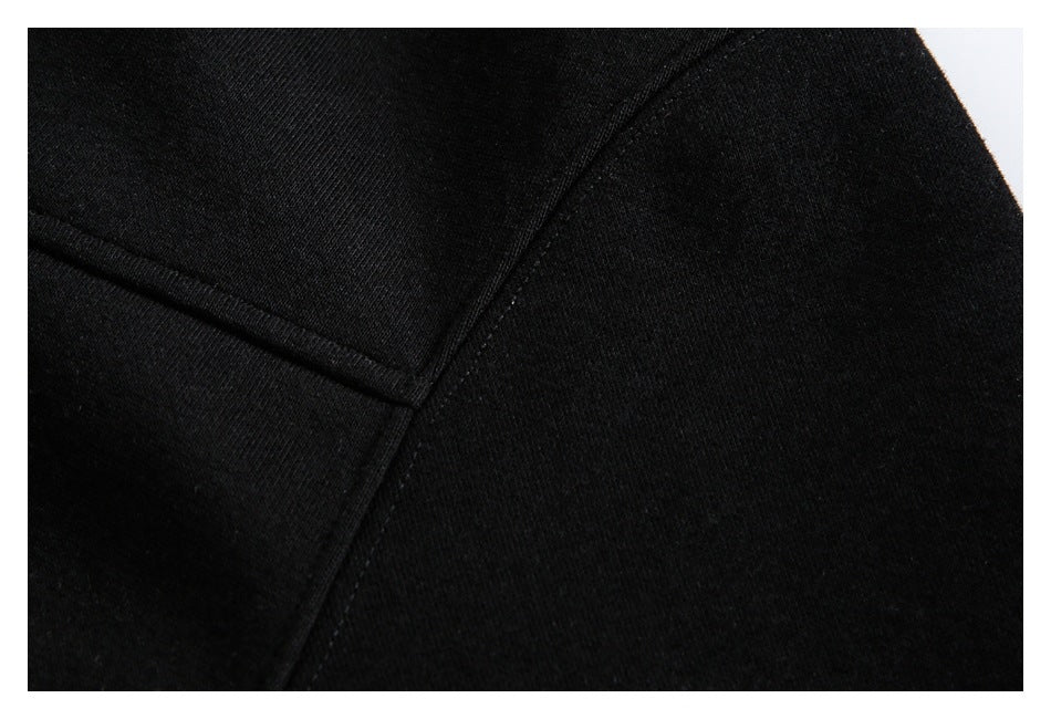 Close-up of black hoodie fabric and intersecting stitched seams.