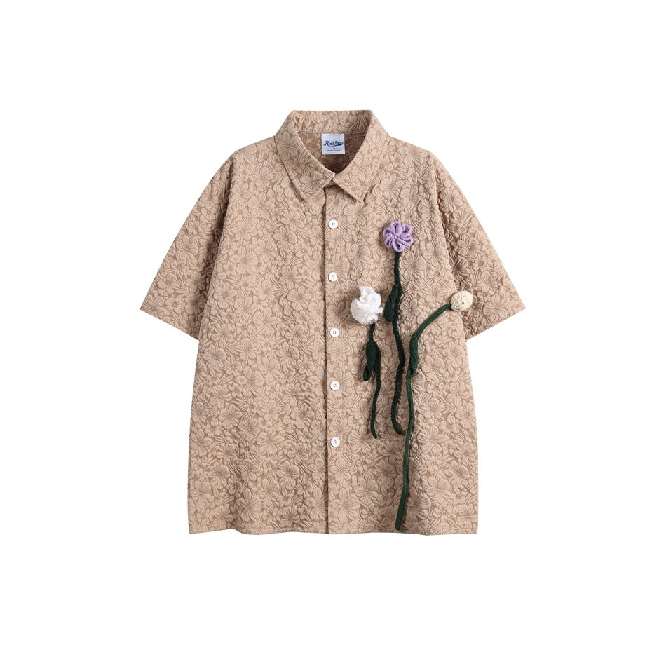 Khaki short-sleeve button shirt with raised floral texture, white buttons and purple and white crochet flowers
