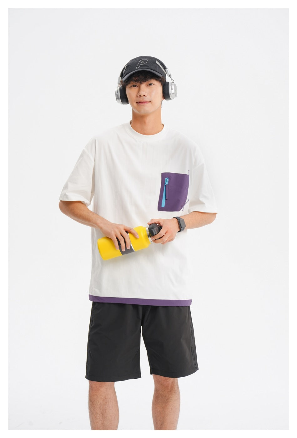 Front view of a model wearing a white oversized tee with a purple zip chest pocket and hem trim.