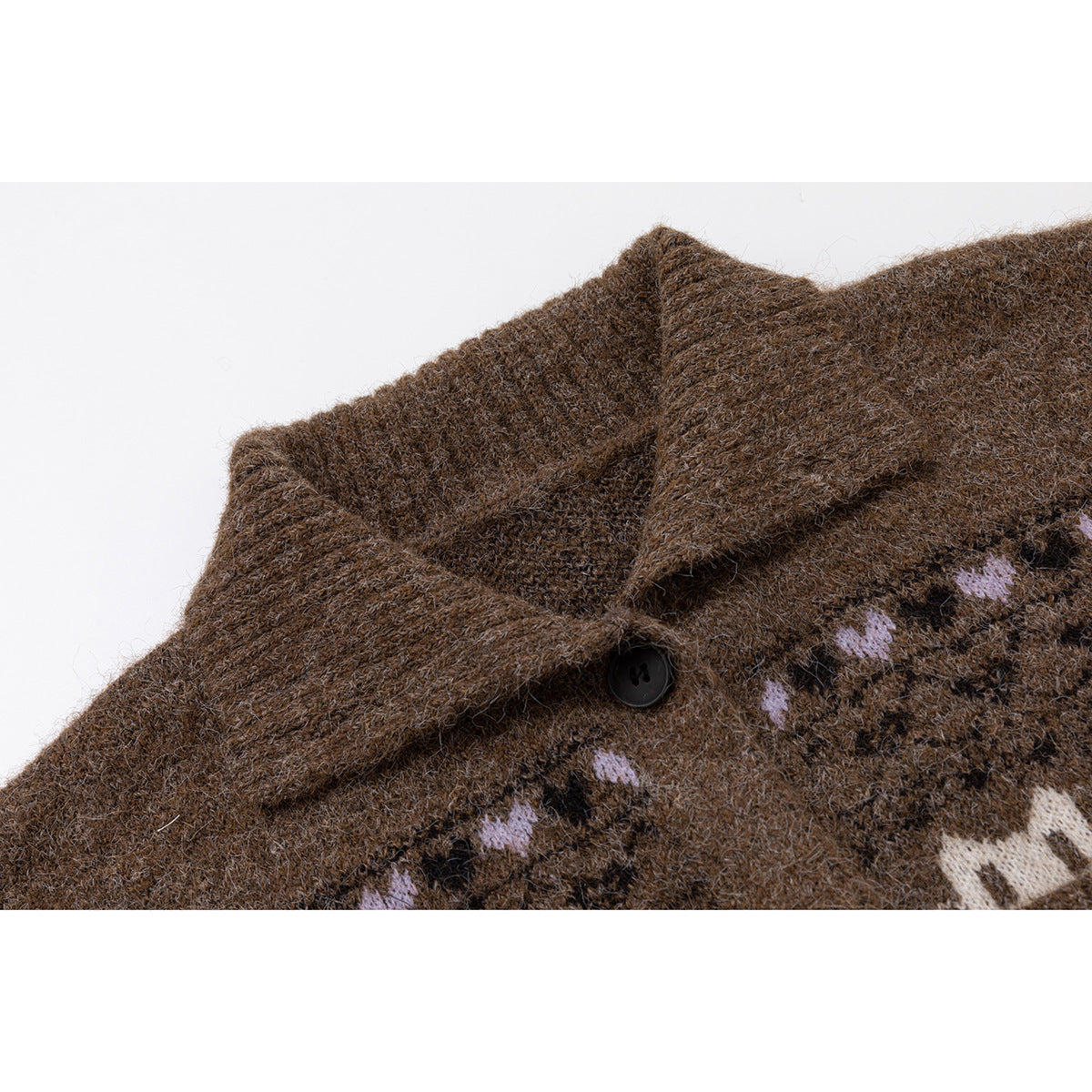 Close-up of a brown knit cardigan's pointed collar, dark button, and lilac patterned band.