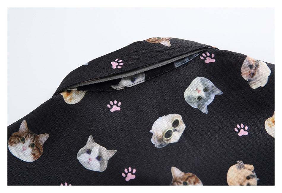 Close-up of the back collar of a black shirt printed with cat faces and pink paw prints.